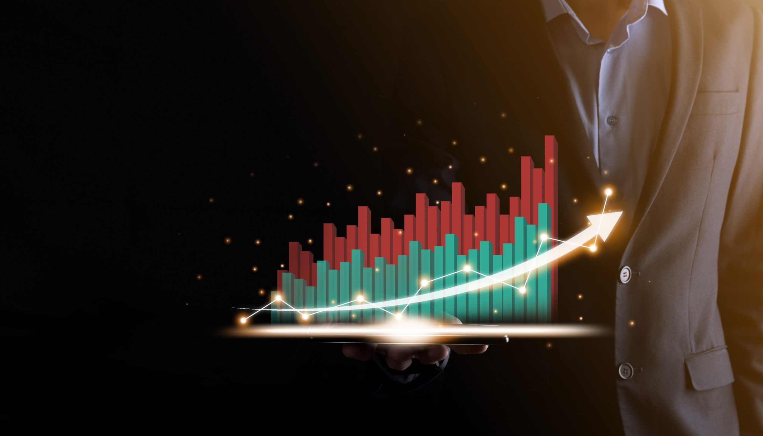 Businessman holding and showing a growing virtual hologram of statistics, graph and chart with arrow up on dark background. Stock market. Business growth, planing and strategy concept